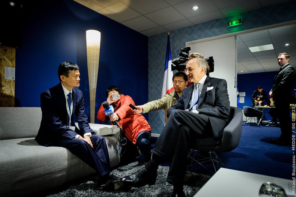 Image of Jack Ma, Alibaba CEO, being interviewed by Laurent Fabius with a TV crew in a dark room in 2015