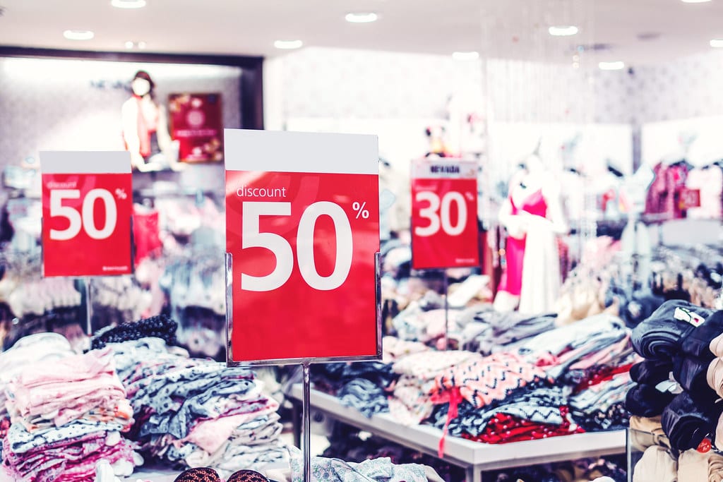 Image of a clothes store with sale signs showing discounts on the products