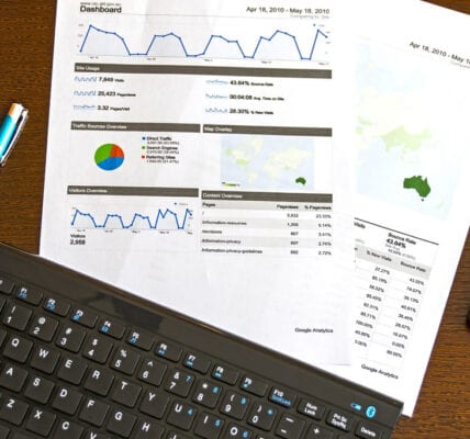 Image of page with digital marketing analytics lying underneath a keyboard
