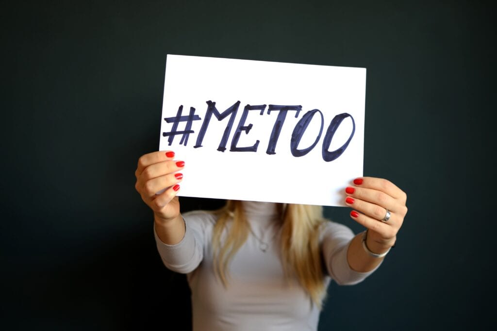 An image of a woman holding a page with the #METOO movement.