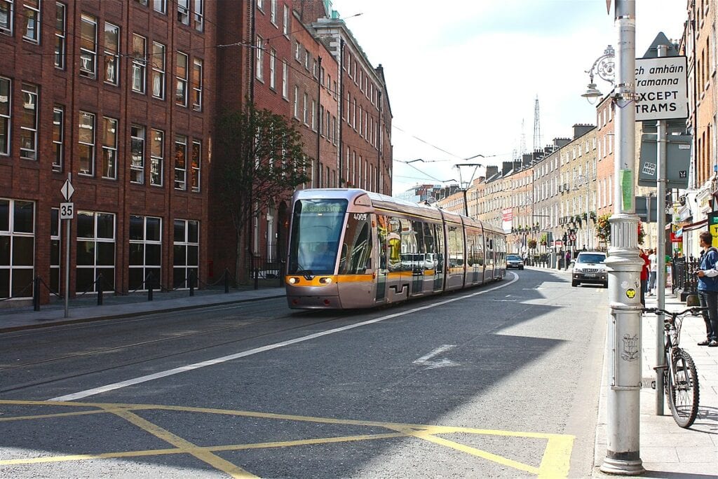 A Luas destined for St. Stephen's Green driving down Harcourt Street on a sunny day in Dublin.