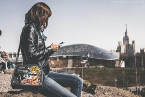 Woman on smartphone outdoors representing 'I Want-to-Go' Micro-Moments.