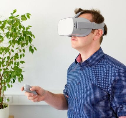 A man with a virtual reality headset and a plant behind him