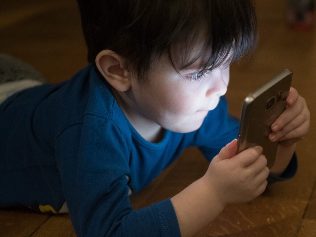 Image of a child, a common target of social media marketing, using an electronic device.