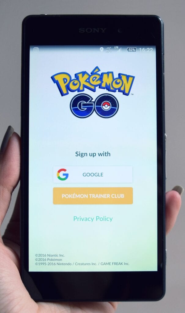 This image shows a person holding a smartphone with the Pokemon GO app open. 