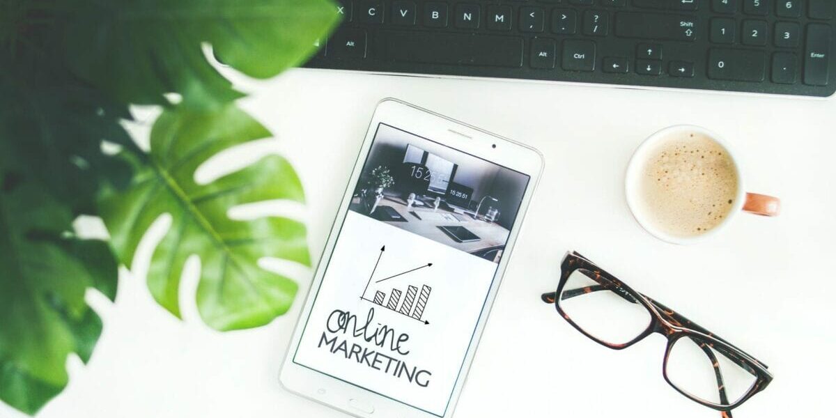 Image of a phone on a desk with "Online Marketing" written on the phone. Organic Reach is one element of online marketing.