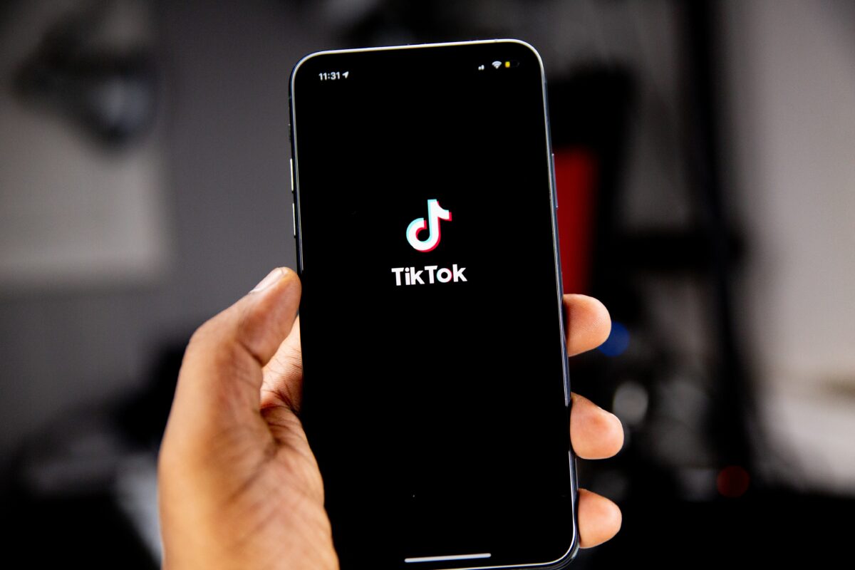 Person holding phone with vivid TikTok logo