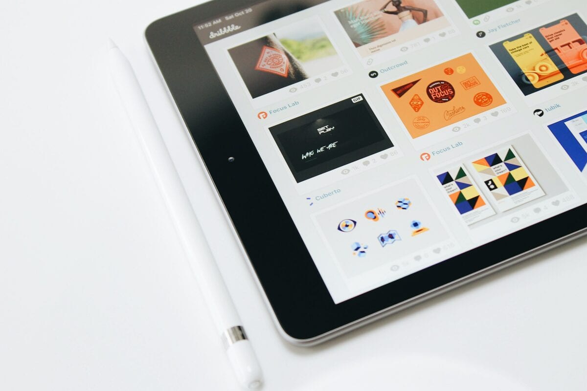 An iPad and Apple Pencil with graphic design content on the screen.