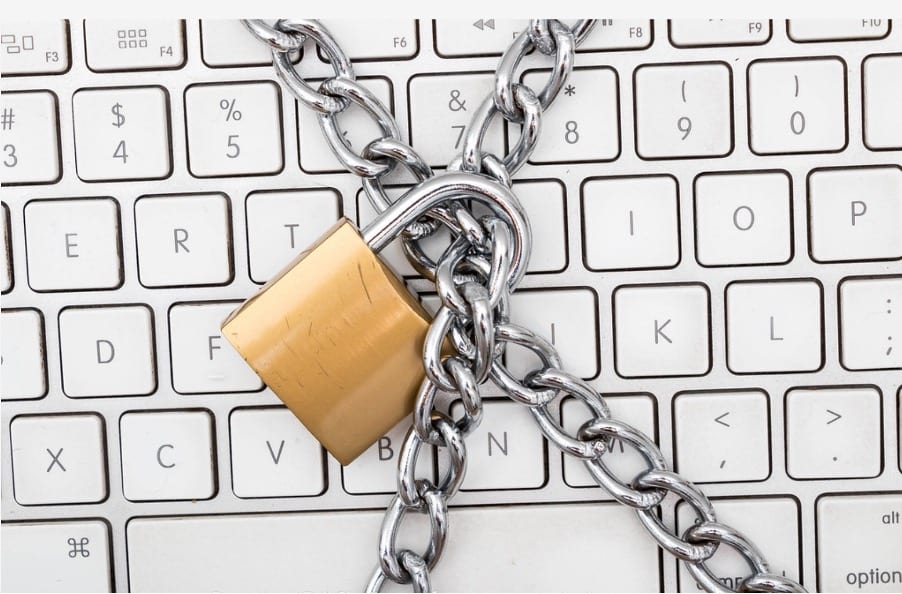 Image of a computer keyboard with a lock and metal chains over it