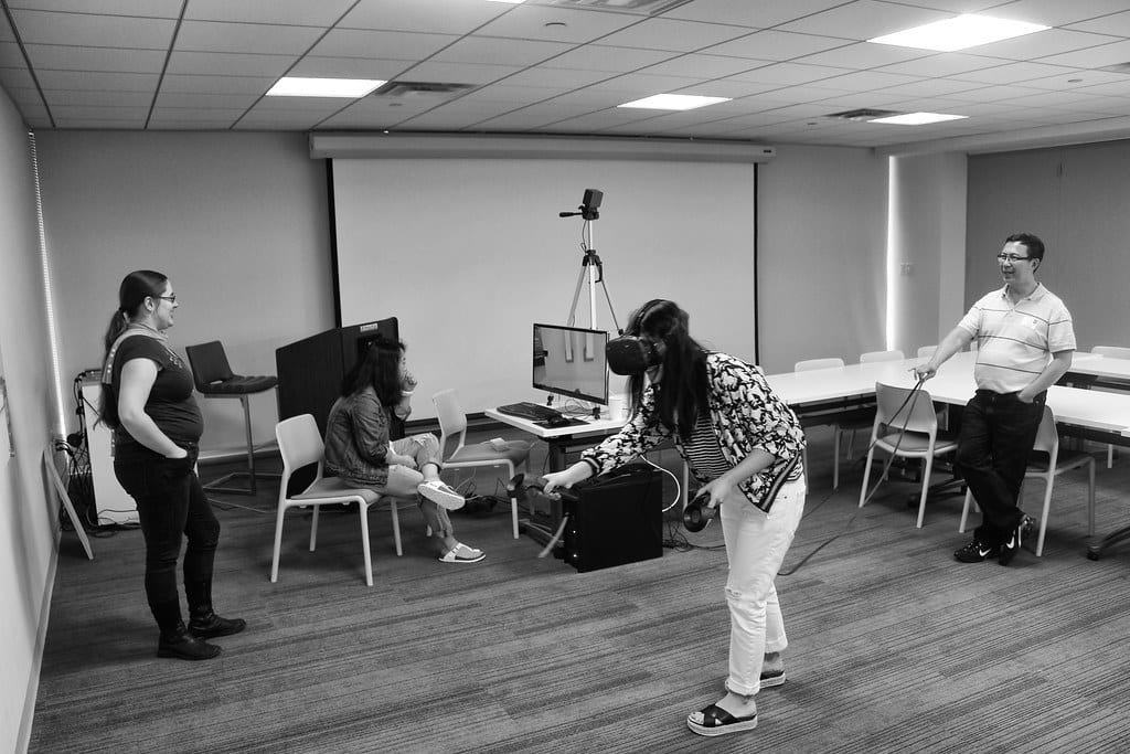 Image of a woman in a virtual reality lab in a classroom environment.