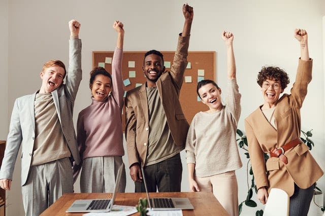 Multi-cultural people raising their firsts to the sky after debunking fake news
