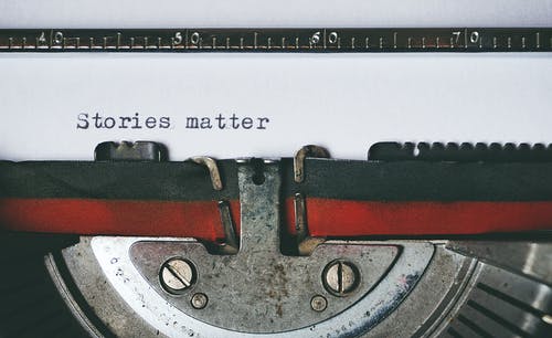 Picture of typewriter typing "Stories matter" on white paper