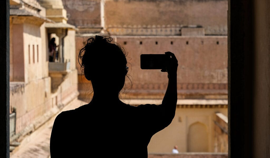 A woman taking a selfie on her smart phone.