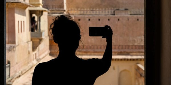 A woman taking a selfie on her smart phone.